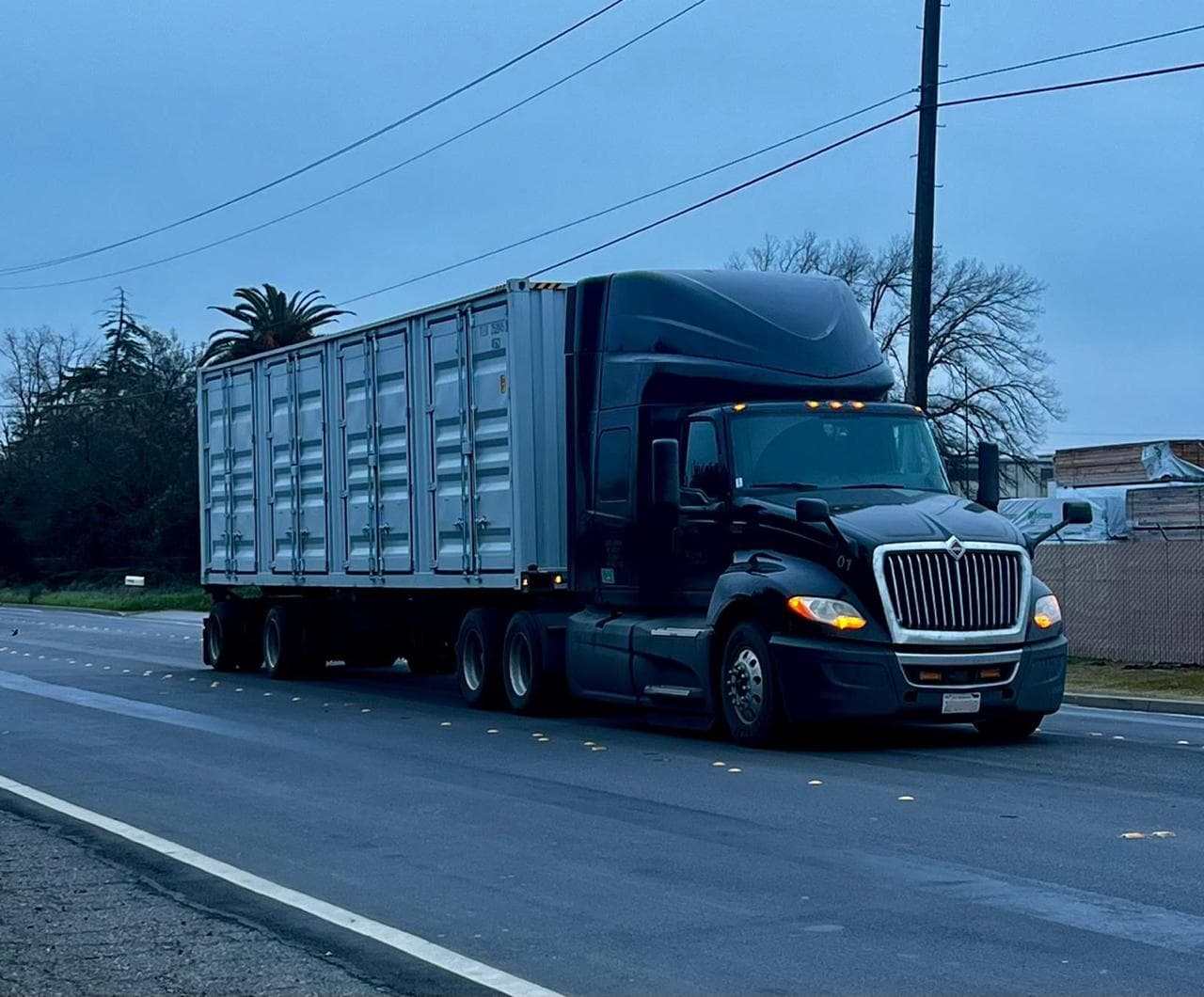 Avtar Freightways truck pulling an enclosed trailer at dusk