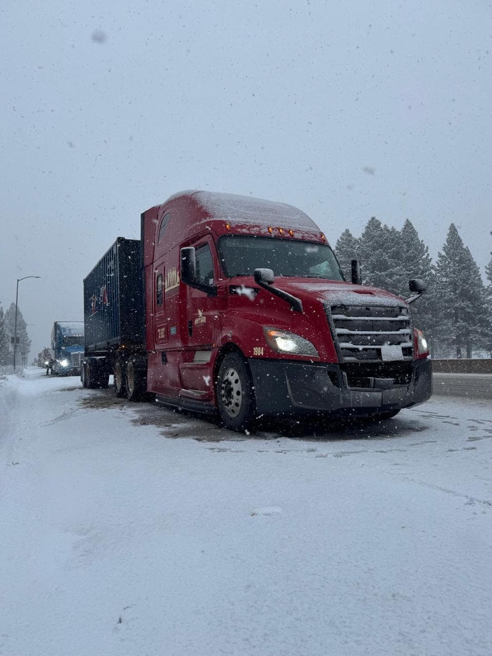 Avtar Freightways truck hauling a container through snow on a mountain highway