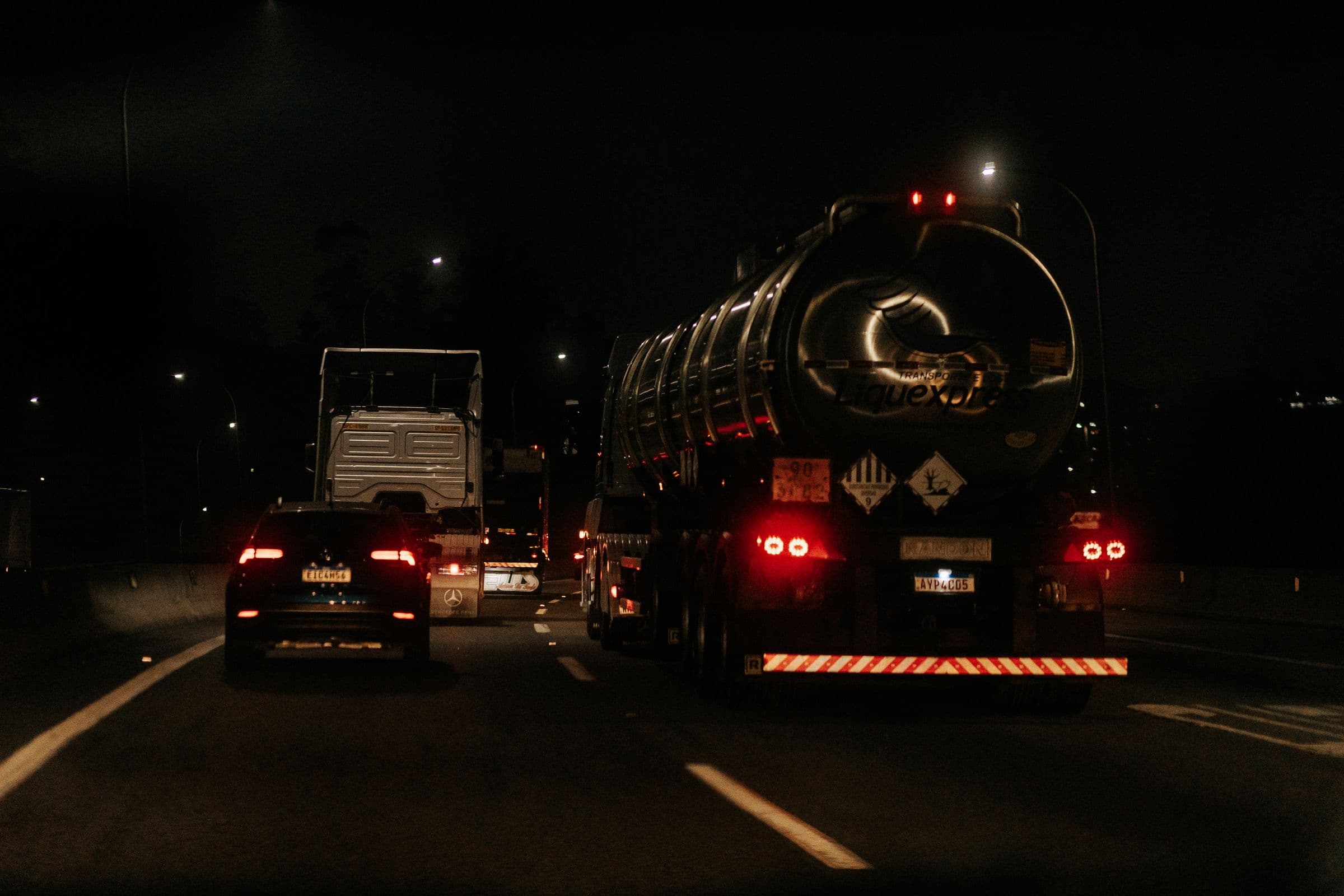 Trucks running a dark highway at night