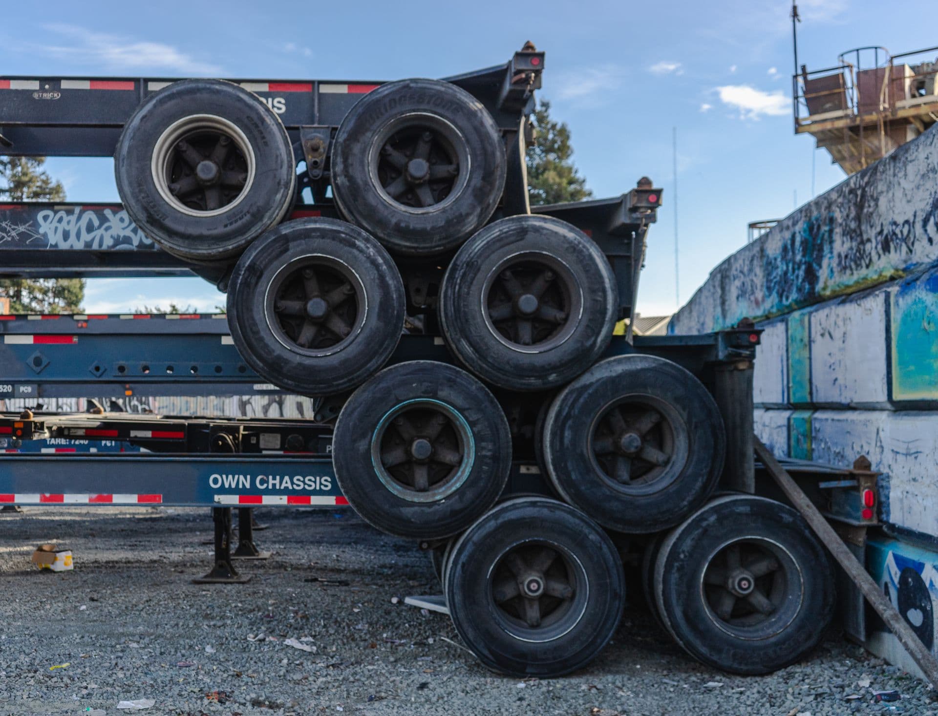 Stack of truck tires mounted on a chassis trailer in a yard