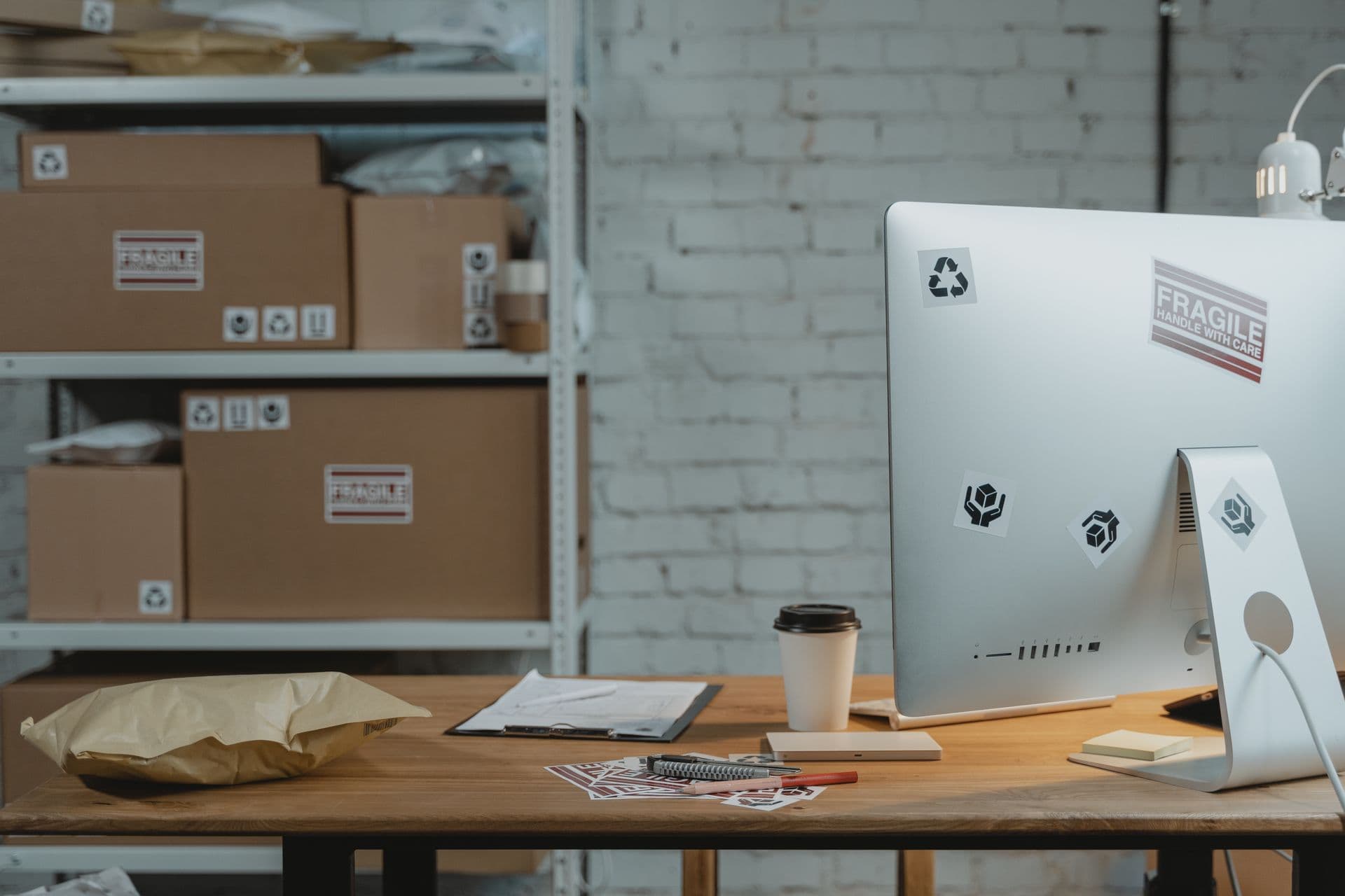 Office desk with a computer, coffee, and shipping boxes