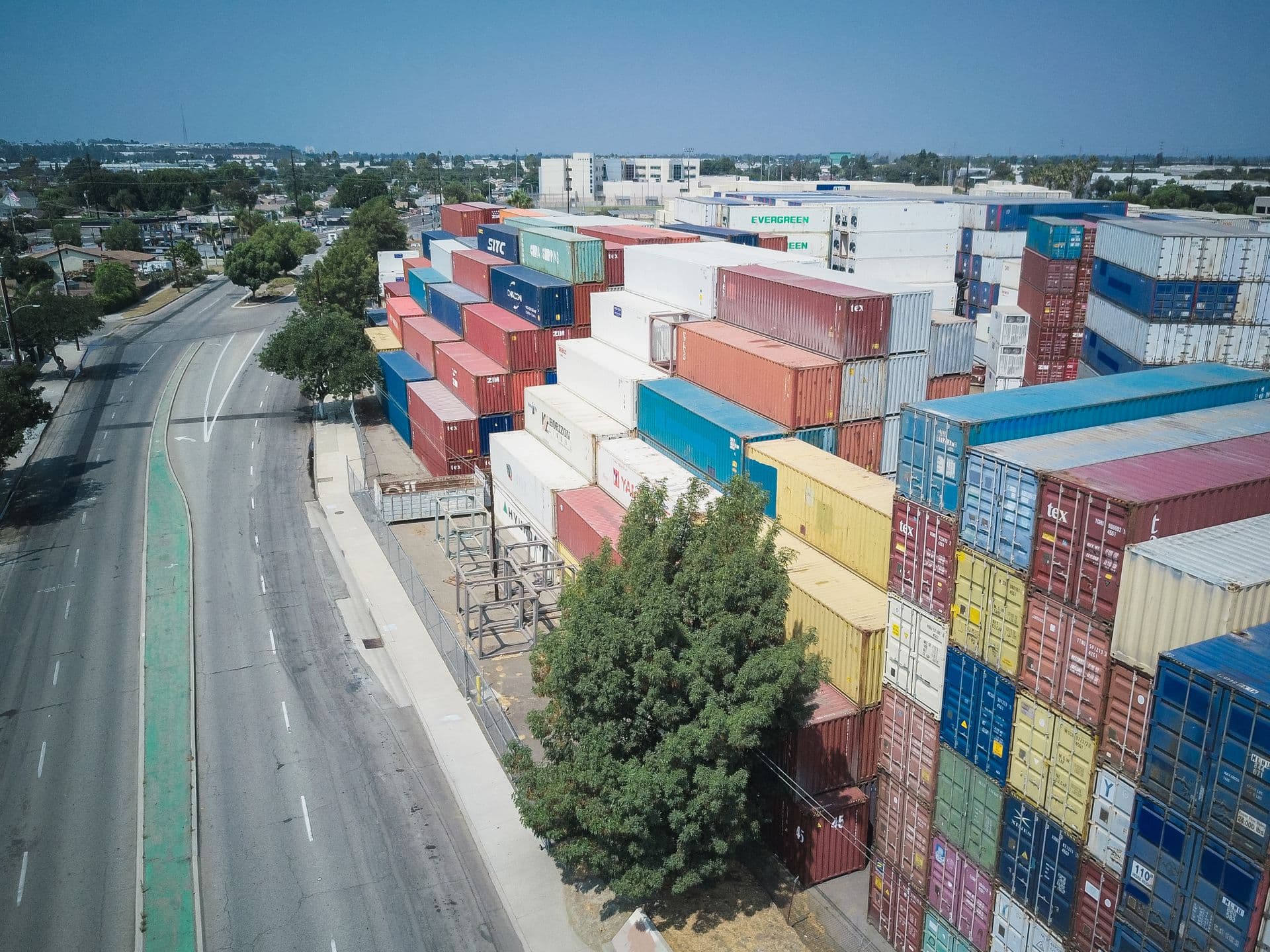 Aerial view of colorful shipping containers stacked beside a road