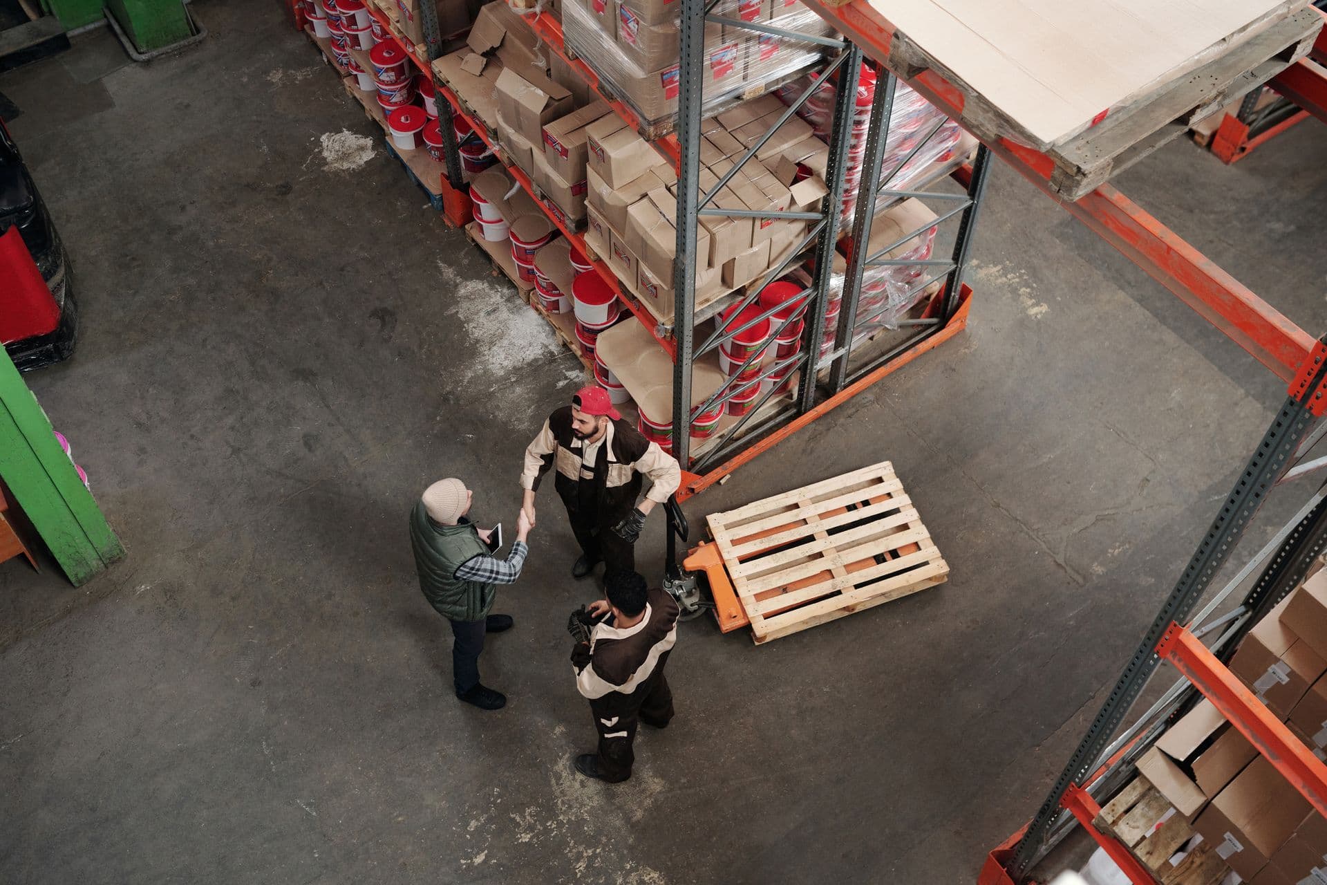 Aerial view of warehouse workers shaking hands