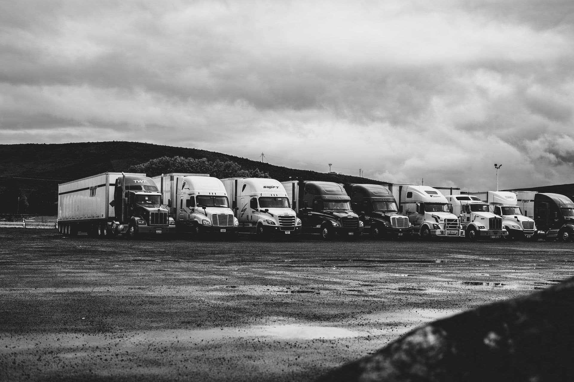 Row of parked semi trucks, black and white photo